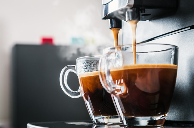 freshly brewed coffee is poured from the coffee machine