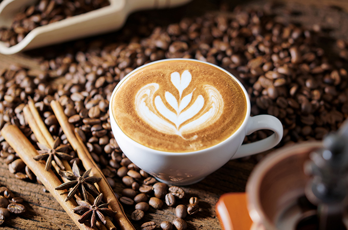white coffee cup and roasted coffee beans around